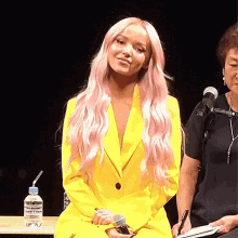 a woman with pink hair wearing a yellow jacket