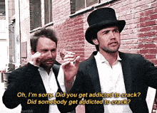 two men standing next to each other with one wearing a top hat and the other wearing a suit