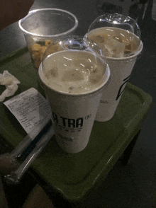 two cups of a tra coffee are on a green tray