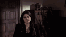 a woman with dark hair is looking at the camera