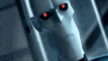 a close up of a robot with red eyes and a serious look on his face .
