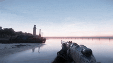 a person holding a gun overlooking a body of water