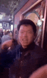 a blurry picture of a man standing in front of a sign that says ' a & b ' on it