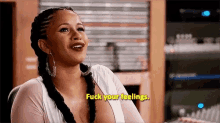 a woman in a white top is sitting in a chair and says `` fuck your feelings '' .