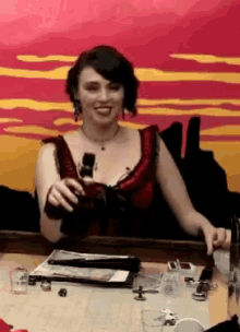 a woman is sitting at a table holding a bottle of wine