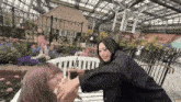 two women are sitting on a bench and one of them is holding a drink