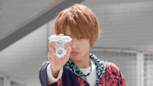 a young man is holding a toy in his hand and making a face