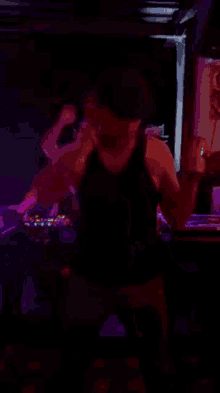 a woman is kneeling down in a dark room with purple lights behind her .