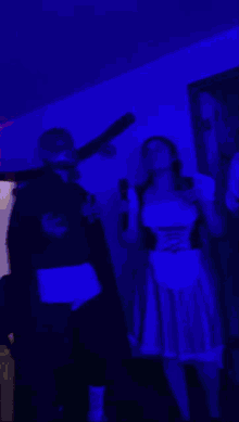 a man in a mask and a woman in a red dress are dancing