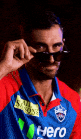 a man wearing sunglasses and a jersey that says hero