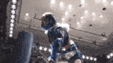 a wrestler in a blue mask holds a sword in her hand