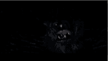 a close up of a werewolf 's mouth with its teeth visible in the dark .