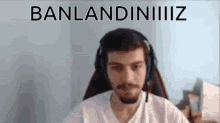 a man wearing headphones is sitting in front of a screen that says banlandininiiiz