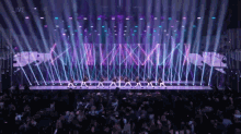 a group of people are dancing on a stage with the word live in the background