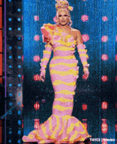 a woman in a pink and yellow dress with flowers on it