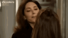 two women are standing next to each other in a room and looking at each other .