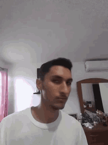 a man is standing in front of a mirror in a room