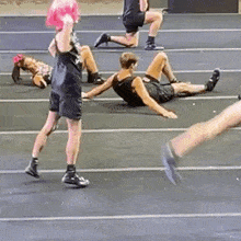 a group of people are doing exercises in a gym .