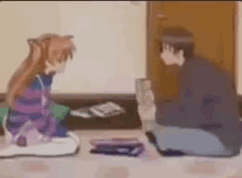 a man and a woman are sitting on the floor playing a game .