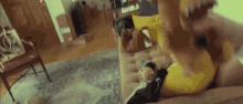 a person in a yellow shirt is laying on a couch in a room