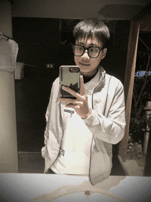 a man taking a picture of himself in a mirror with a phone case that says converse