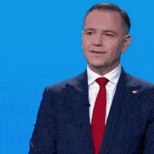 a man in a suit and tie is singing into a microphone while standing at a podium ..
