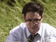a man wearing glasses and a white shirt and tie