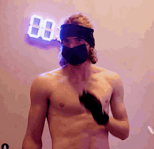 a shirtless man wearing a black mask stands in front of a neon sign that says 88