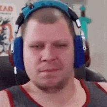 a man wearing headphones is sitting in a chair and making a funny face .