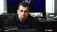 a man sitting in front of a laptop with the nbc logo on the bottom right