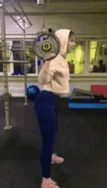 a woman squatting with a barbell on her back