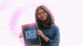 a girl is holding a book titled ignite