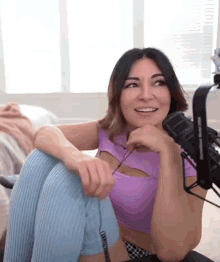 a woman is sitting on a chair in front of a microphone .