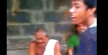 a blurry picture of a man standing next to another man .