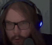 a pixelated image of a man with long hair and glasses wearing headphones