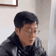a man wearing glasses and a black jacket
