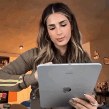 a woman is using an apple ipad in a living room