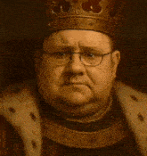 a fat man wearing a crown and glasses is holding a ring .