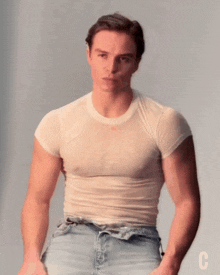 a man is wearing a white t-shirt with the letter c on the bottom right