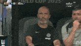 a man wearing a shirt that says bin is smiling