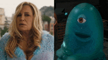a woman in a blue sweater next to a blue cartoon character