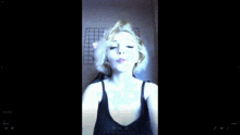 a woman with blonde hair is smoking a cigarette