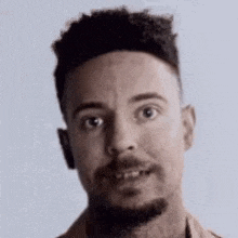 a close up of a man 's face with a beard .