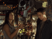 a man and a woman are standing in a room with a sign that says ' a / u '
