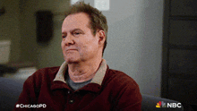 a man sitting on a couch with #chicagopd written on the bottom right