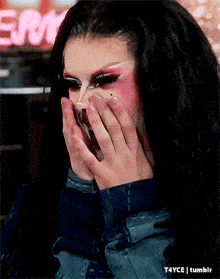 a close up of a drag queen covering her face with her hands and a t4yce tumblr logo in the corner