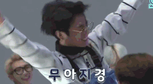 a man with his arms outstretched is wearing glasses and a white shirt with the word vlive on the bottom