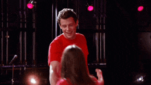 a man in a red shirt is holding a woman in a red shirt