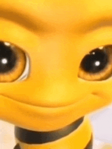 a close up of a yellow cartoon character with big eyes and a smile on its face .