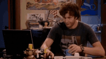 a man wearing a t-shirt that says ' always ' on it is sitting at a desk